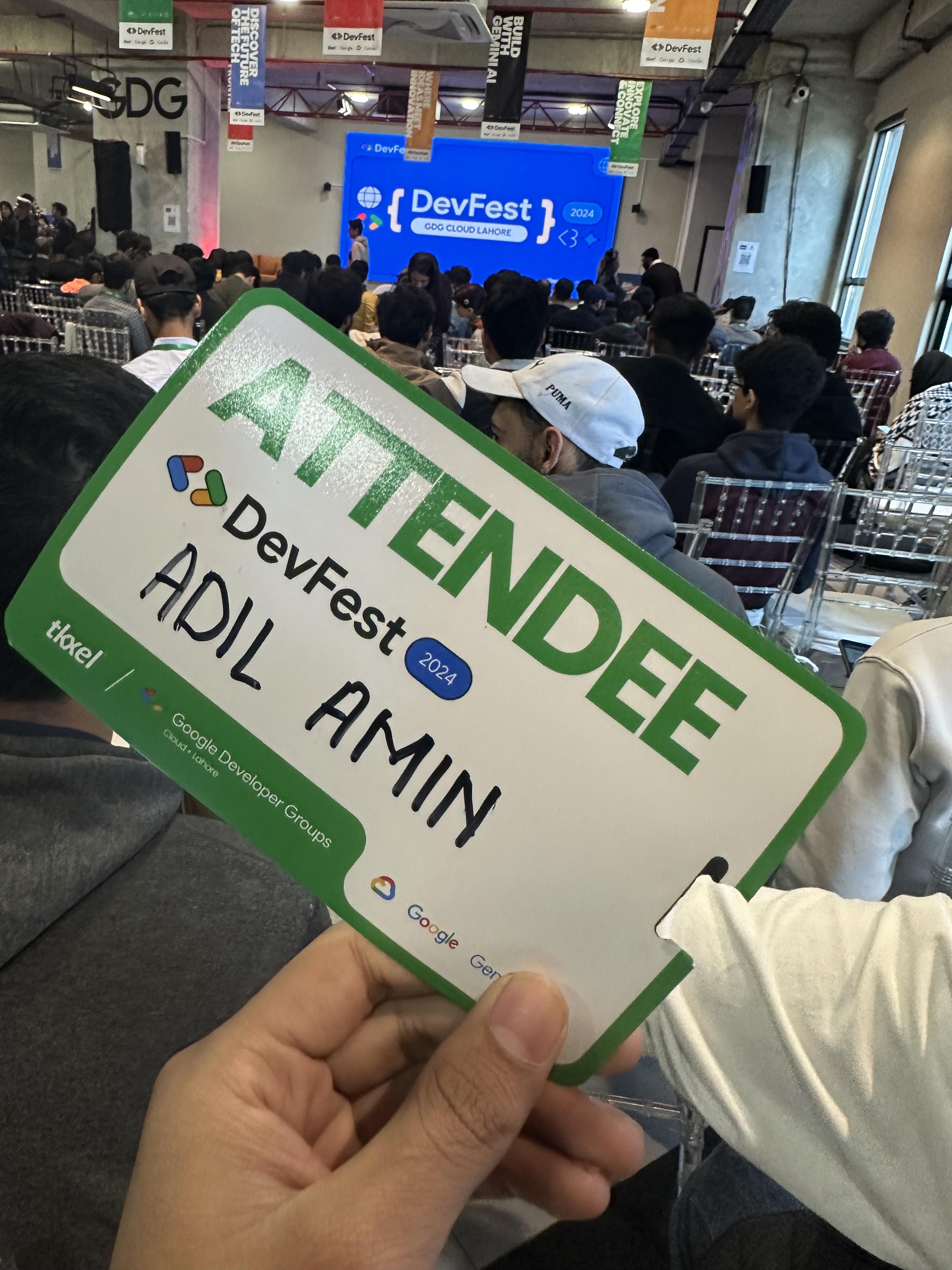 Engineer Adil Amin attendee badge in front of the audience at DevFest, GDG Cloud Lahore